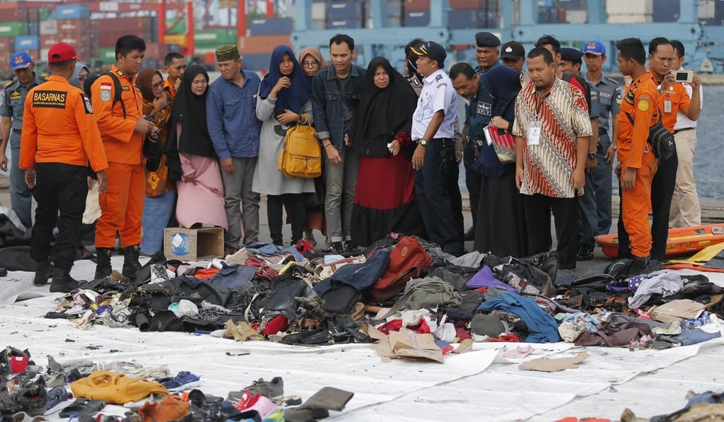 Relatives of passengers check personal belongings retrieved from the sea near where the doomed Lion Air jet crashed. Photo: AP Relatives of passengers check personal belongings retrieved from the sea near where the doomed Lion Air jet crashed. Photo: AP