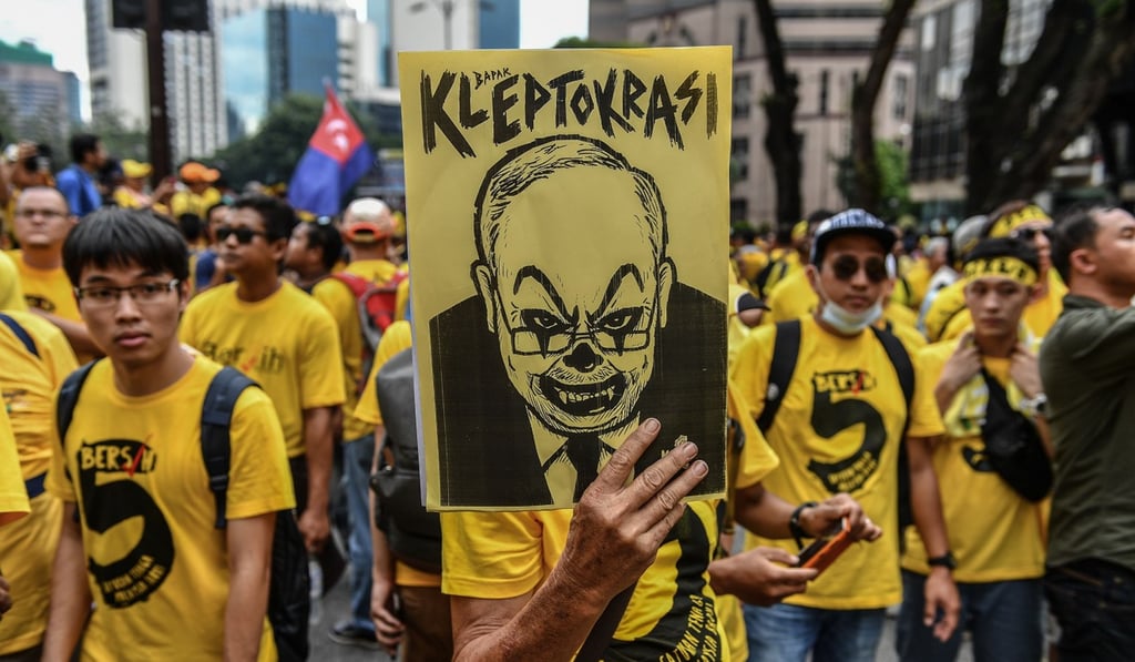 A protester holds a placard with a caricature depicting then Malaysian prime minister Najib Razak during a mass rally calling for Razak’s resignation, in Kuala Lumpur, on November 19, 2016. Photo: AFP