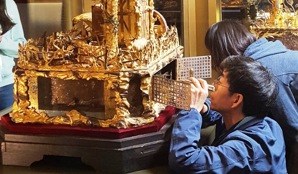 Wang Jin (front) and Guan Xueling, both research fellows at The Palace Museum in Beijing, make some final adjustments to Emperor Qianlong’s restored clock before the start of the ‘Treasures of Time” exhibition at Hong Kong Science Museum. Photo: The Palace Museum