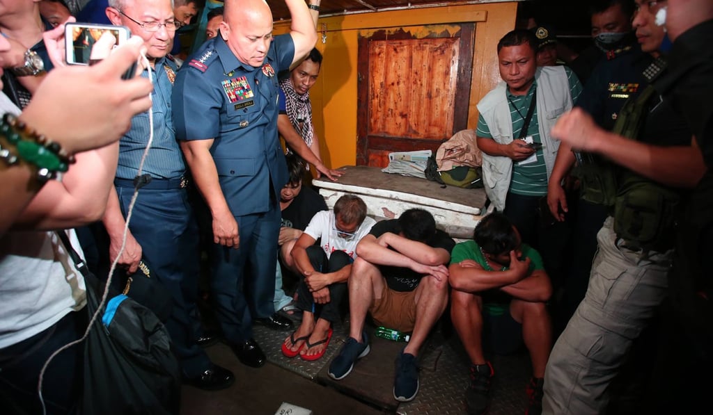 The group (pictured sitting) were detained in July 2016 on board a 50-metre fishing boat about 3km off the coast of Zambales province, northwest of Manila. Photo: Handout