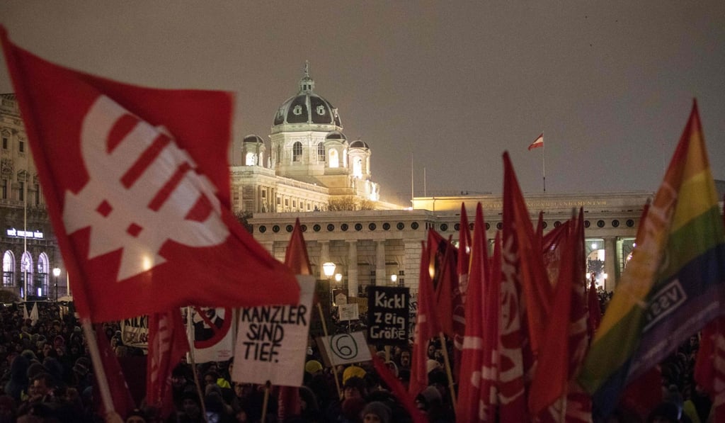 A demonstrator with a flag (L) of the Social - Democratic Party Austria ( SPOe) takes part in a rally at the Heldenplatz a year after the formation of a government by the Conservative Oevp - FPOe on December 15, 2018 in Vienna. Photo: AFP