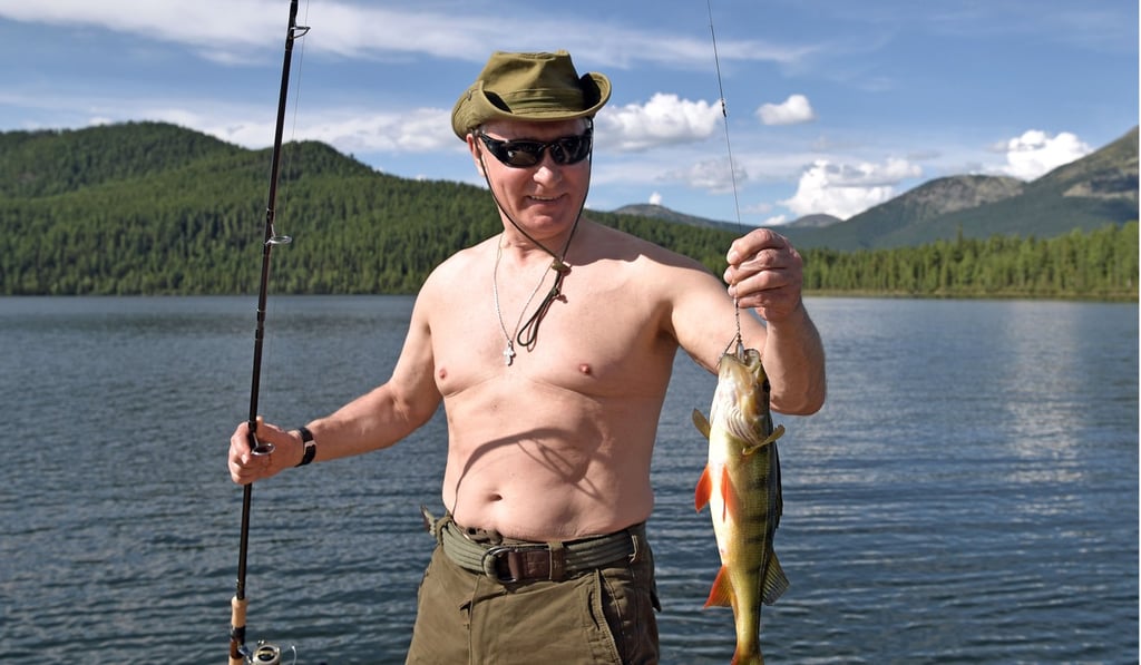 Russian President Vladimir Putin holds a fish he caught in Siberia. Photo: AP