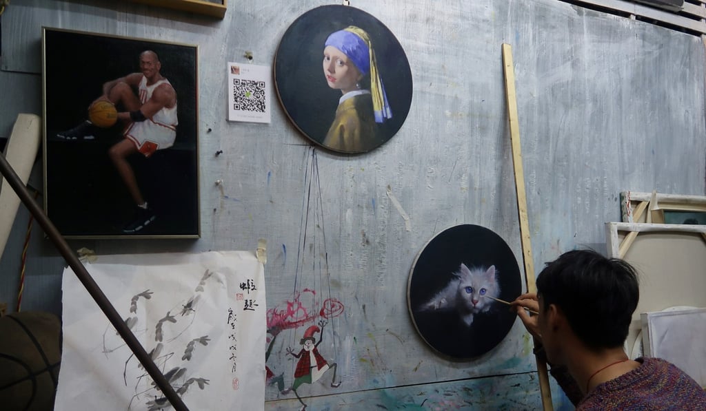 A Chinese artist paints a cat at a studio in Dafen Oil Painting Village in Shenzhen, Guangdong province. Photo: Reuters