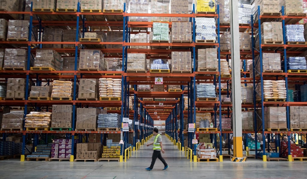A worker walks through a warehouse for online retailer Tmall in Jiangmen, Guangdong province. China’s retail sales in November grew at their slowest pace in 15 years. Photo: EPA