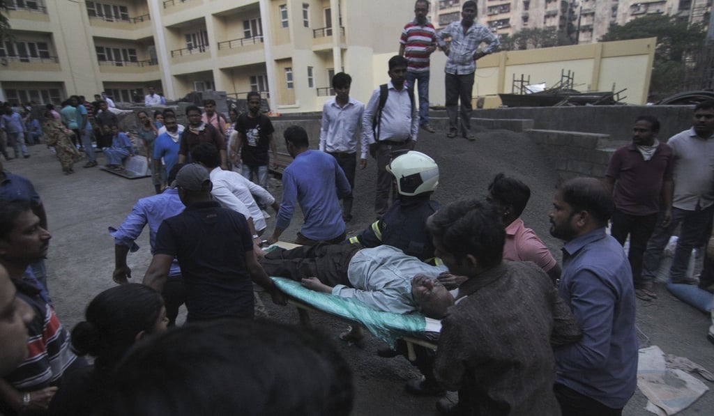 Rescuers carry an injured person on a stretcher away from the fire. Photo: AP Rescuers carry an injured person on a stretcher away from the fire. Photo: AP