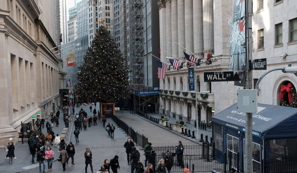 People walk by the New York Stock Exchange (NYSE) and the NYSE Christmas tree on Monday in New York. Photo: Agence France-Presse