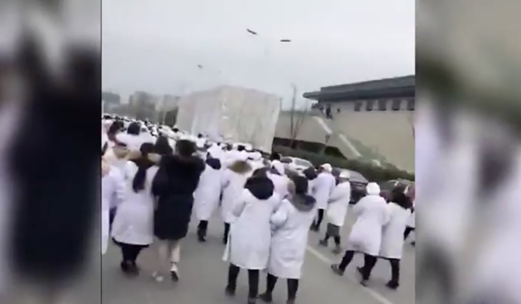 Video footage shows the workers dressed in white uniforms heading towards the office building. Photo: Rfa.org