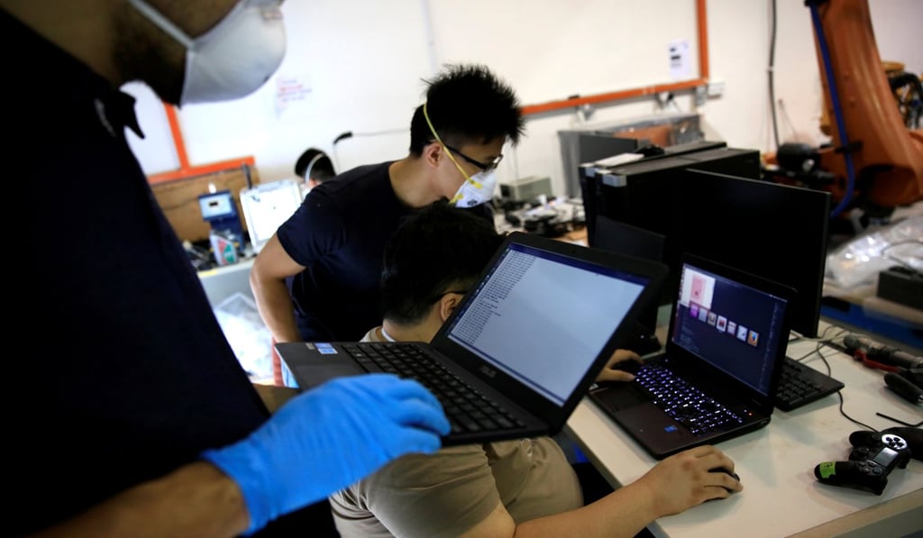 Technicians work on programming a 3D printer at the Nanyang Technological University (NTU) in Singapore in 2017. The National University of Singapore has launched a scheme that offers a high salary and generous research funding to attract research talent not only in the STEM fields but also non-STEM fields such as the humanities. Photo: Reuters
