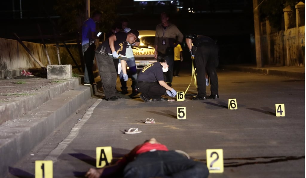 Police at the scene of a suspected drug pusher’s killing in Manila. Photo: EPA