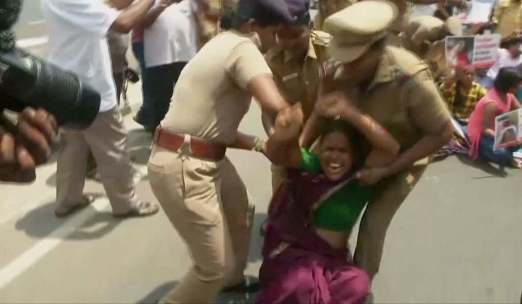 Police remove a woman protesting against the copper smelter. Photo: Reuters