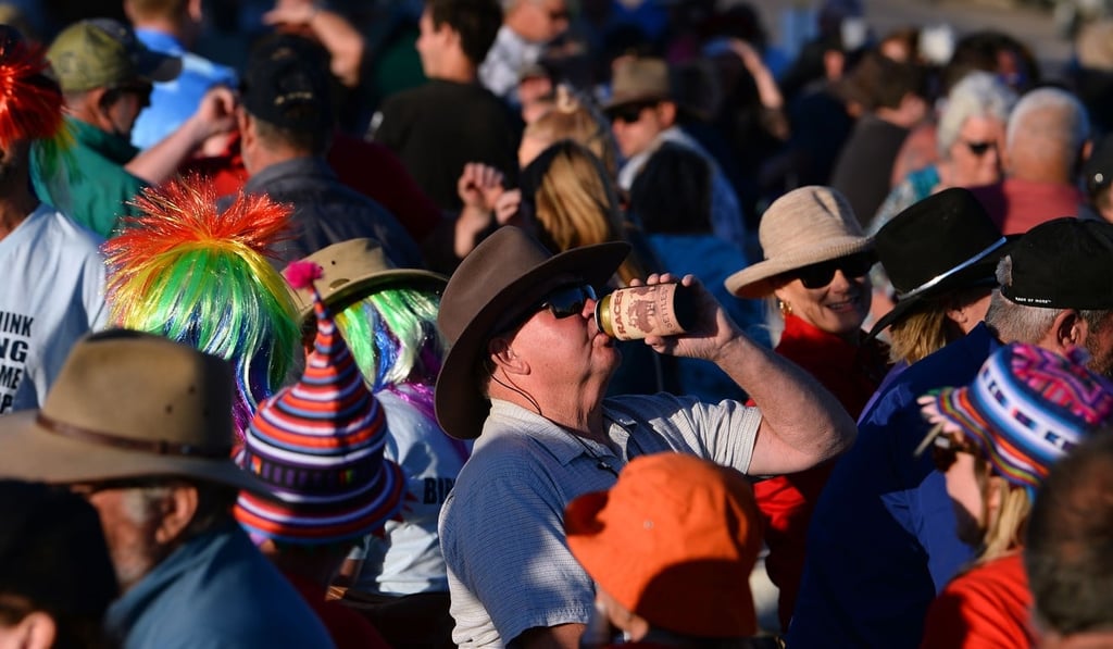 A person enjoying a beer in Birdsville, Australia. Photo: AFP
