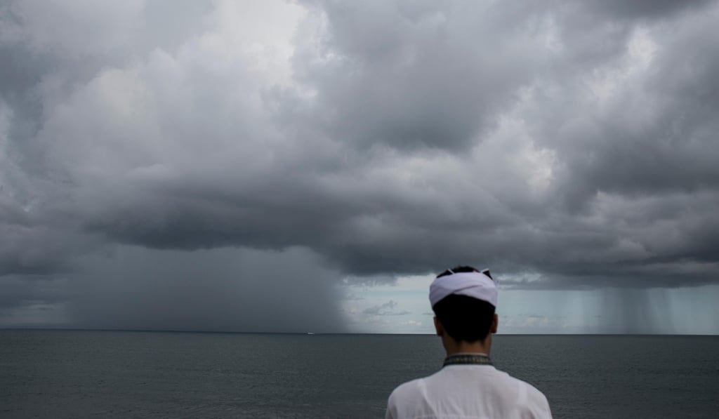 A Balinese man watches as a storm approaches the island. Photo: Alamy