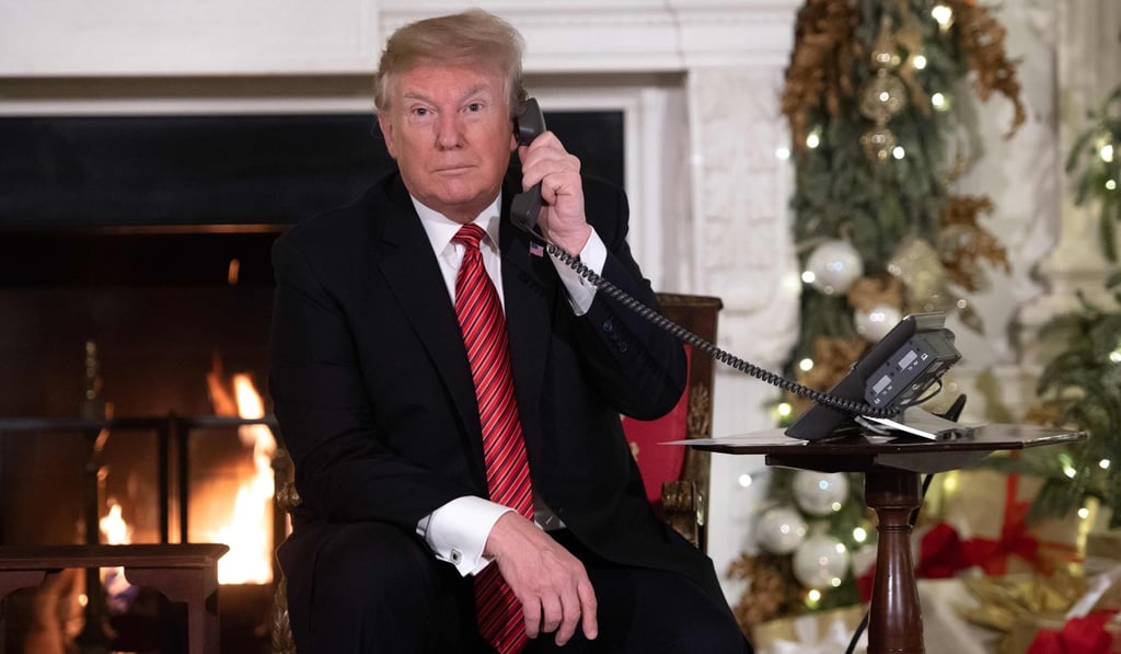 US President Donald Trump speaks on the telephone as he answers calls from people calling into the NORAD Santa tracker phone line. He’s vowed he would not reopen the government until he gets US$5 billion to fund his border wall. Photo: AFP