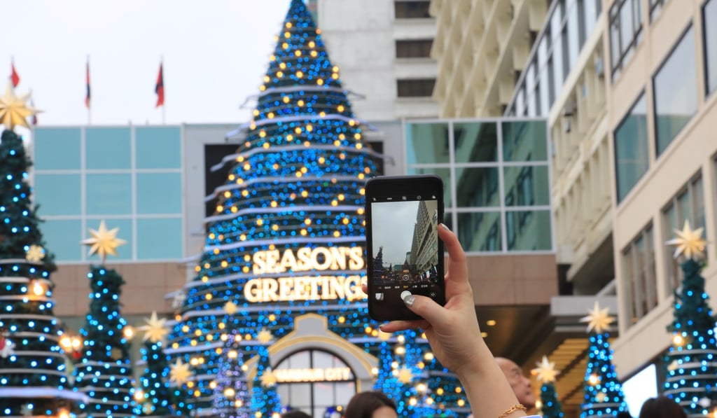 Tourists taking selfies at Harbour City in Tsim Sha Tsui in front of the mall’s Christmas trees. Photo: Vivian Yan Tourists taking selfies at Harbour City in Tsim Sha Tsui in front of the mall’s Christmas trees. Photo: Vivian Yan