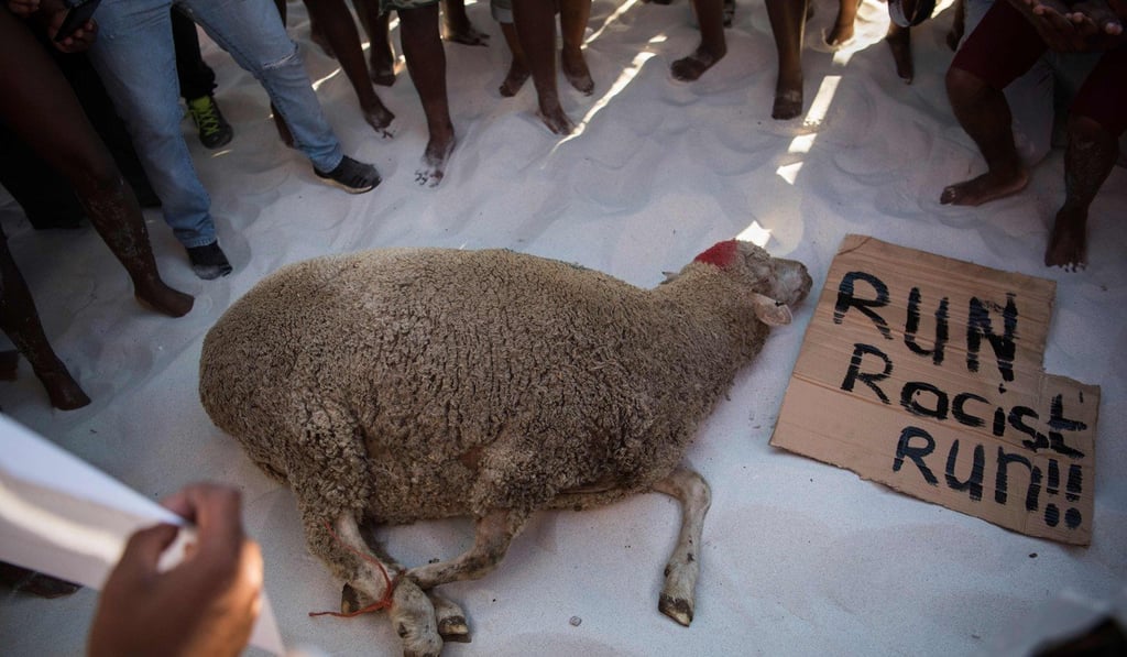 Protesters prepare to slaughter a sheep on Clifton Beach in Cape Town on Friday, in a supposed ritual to tackle racism. Photo: AFP