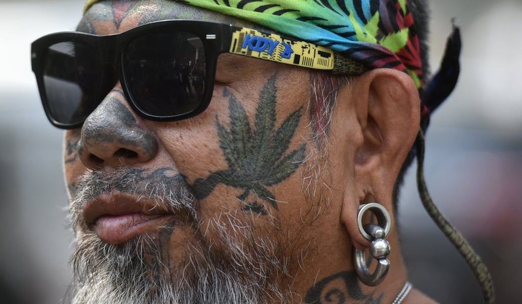 A Thai activist with a marijuana tattoo on his face gathers with others during a campaign for the legalisation of medical marijuana near Government House in Bangkok. Photo: Reuters