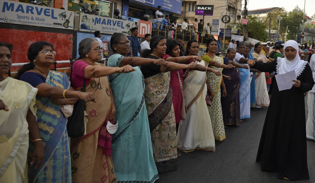 Women raise their hands to take a pledge to fight gender discrimination. Photo: AP Women raise their hands to take a pledge to fight gender discrimination. Photo: AP
