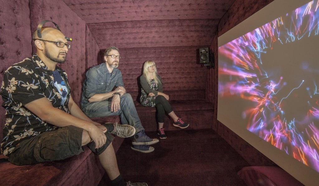 Audience members watching The Moment, which changes scenes depending on brain data received from EEG devices. Photo: Spark
