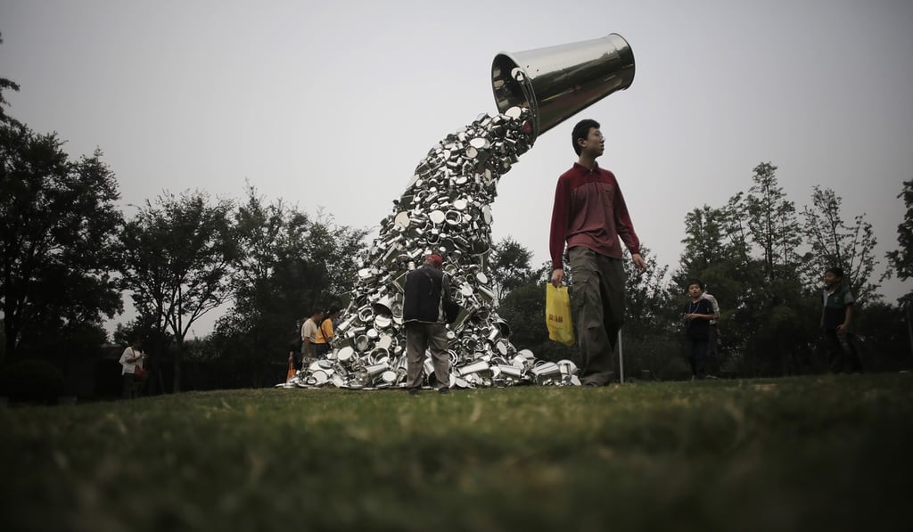 Visitors walk by a sculpture created by Indian artist Subodh Gupta as part of the Jing'An International Sculpture Project Biennial at a park in Shanghai. Photo: AP