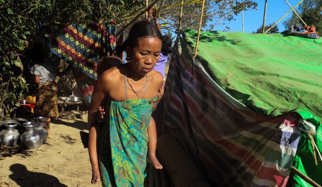 A woman, displaced by violence between ethnic Rakhine rebels and Myanmar’s army, walks with a child at a makeshift camp in Kyauktaw, Rakhine state, on January 5, 2018. Photo: AFP