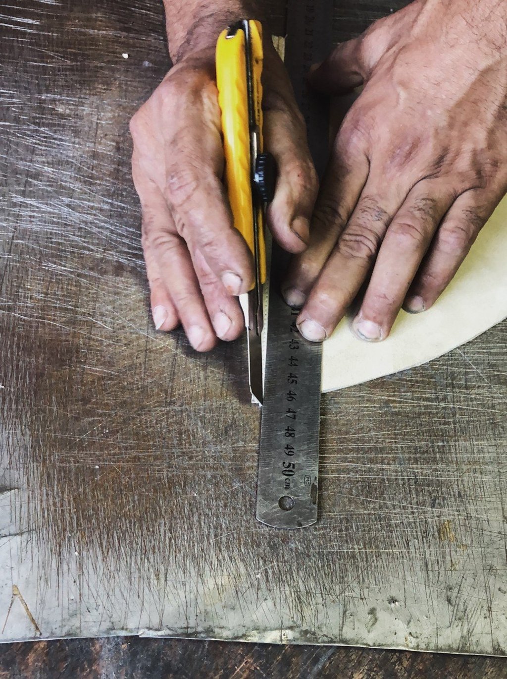 An artisan makes a pair of Lei shoes.