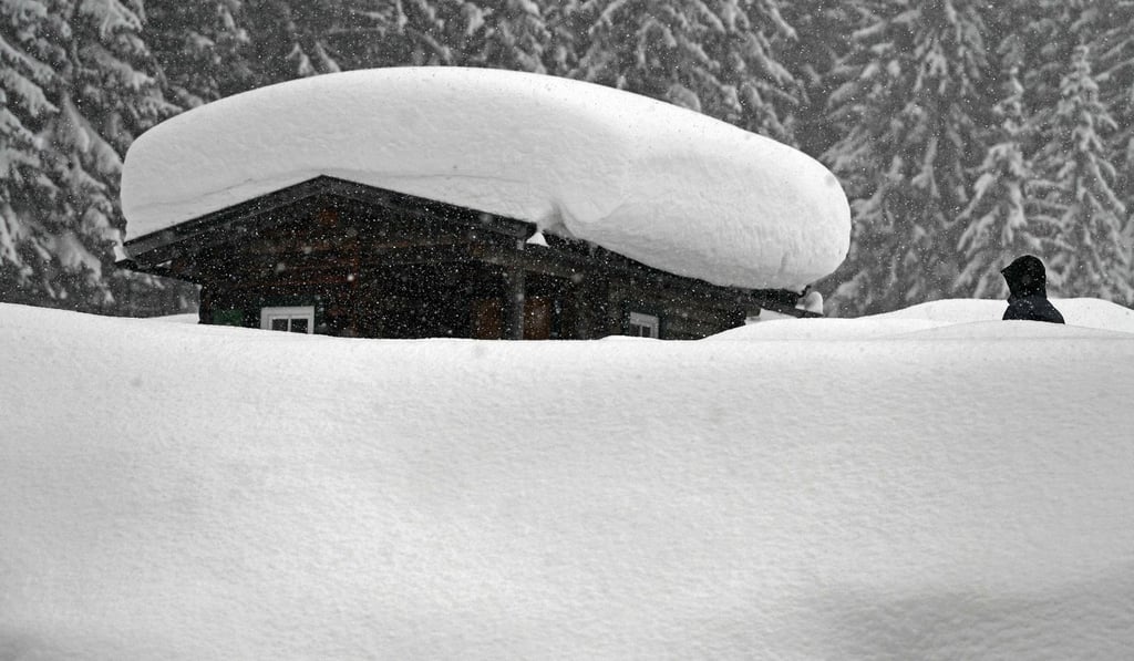 A person walking by a snow-covered hut on Tuesday in Ramsau am Dachstein, Austria. Photo: AFP A person walking by a snow-covered hut on Tuesday in Ramsau am Dachstein, Austria. Photo: AFP
