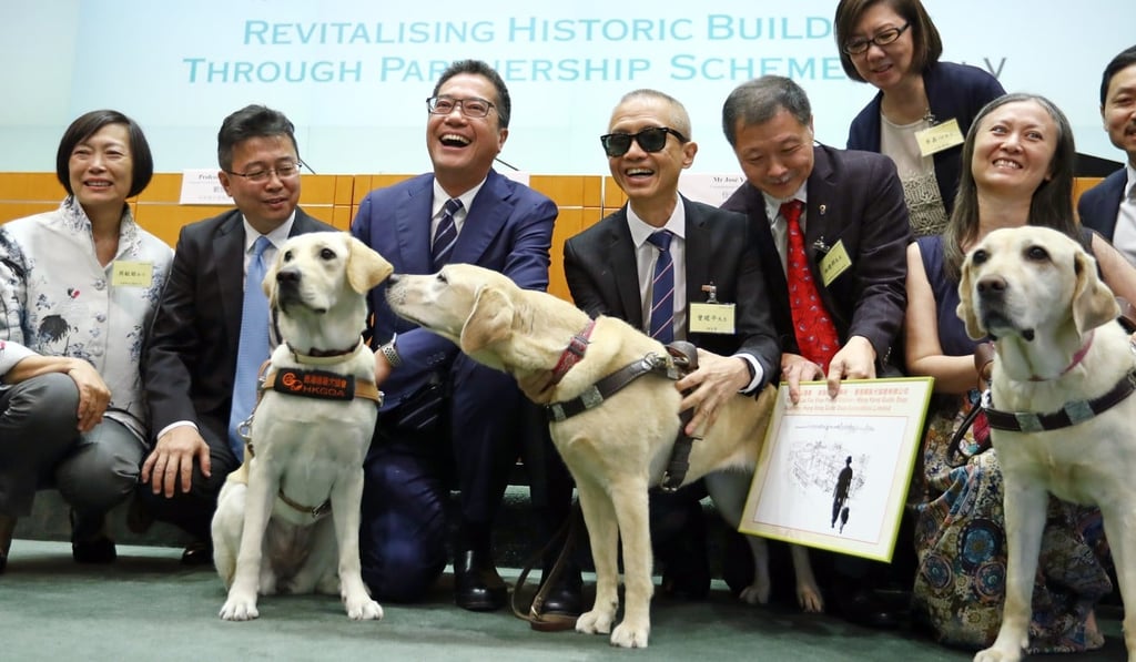 Secretary for Development Michael Wong (third from left) poses with representatives from Hong Kong Guide Dogs Association Limited, which successfully applied for revitalisation of the former Lau Fau Shan Police Station into the Hong Kong Guide Dogs Academy, in July 2018. Photo: Nora Tam