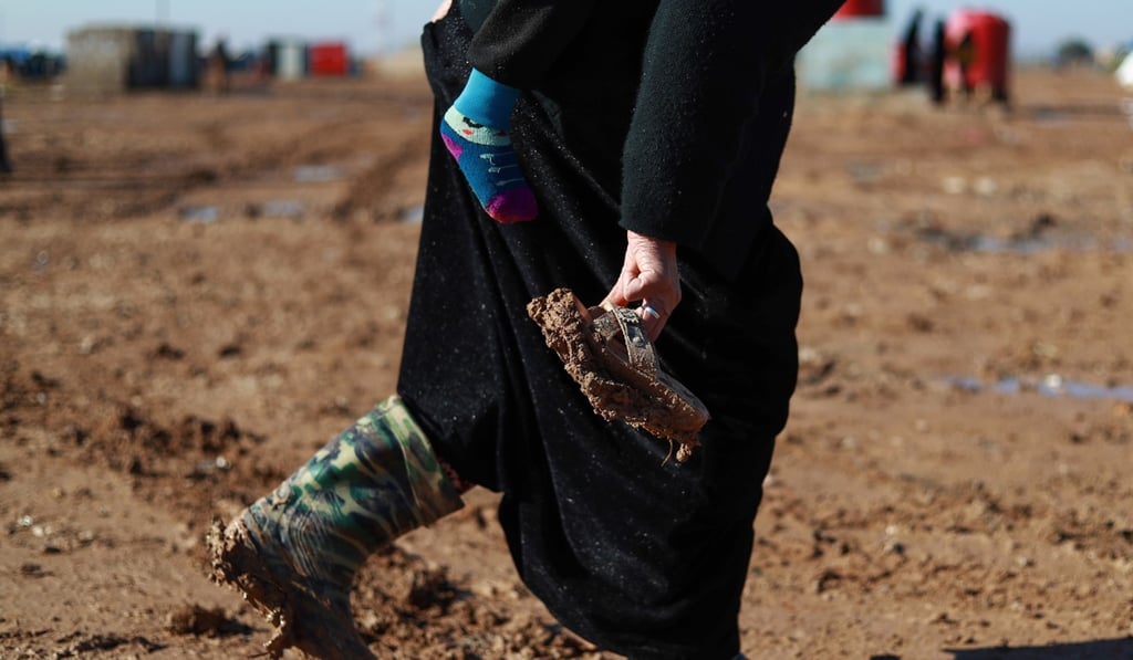 A Syrian woman walks in mud while carrying a child on her back and holding a pair of muddy slippers in Abu Al-Khashab camp for the displaced from the eastern province of Deir Ezzor, northwest of the city of Deir Ezzor, on January 10, 2019. Photo: AFP A Syrian woman walks in mud while carrying a child on her back and holding a pair of muddy slippers in Abu Al-Khashab camp for the displaced from the eastern province of Deir Ezzor, northwest of the city of Deir Ezzor, on January 10, 2019. Photo: AFP