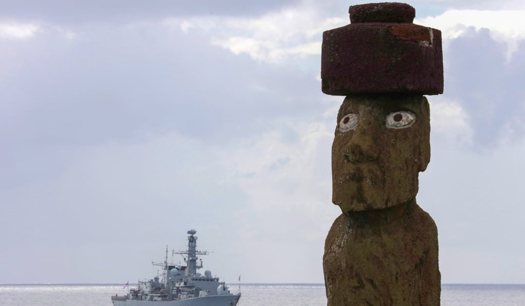 A handout picture provided by the British Ministry of Defence showing a lone moai on Easter Island with HMS Montrose behind on December 27. Photo: EPA