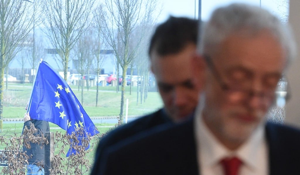 A lone anti-Brexit supporter stands with an EU flag as opposition Labour party leader Jeremy Corbyn gives a speech on Brexit at a manufacturing plant in Wakefield, north England on Thursday. Photo: AFP