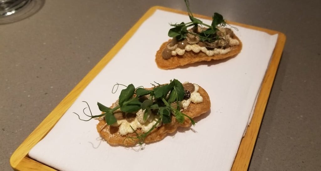 Mushroom crackers with fermented mushroom and piped yeast purée, pickled shemeji mushrooms, cream cheese, toasted yeast flakes, and kale shoots and chrysanthemum flowers sourced from a local organic farm Mushroom crackers with fermented mushroom and piped yeast purée, pickled shemeji mushrooms, cream cheese, toasted yeast flakes, and kale shoots and chrysanthemum flowers sourced from a local organic farm