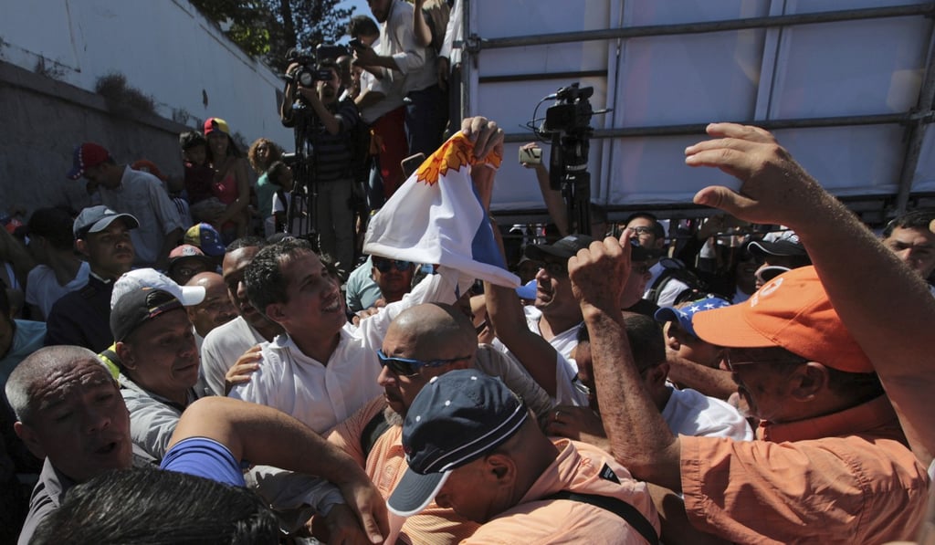 National Assembly President Juan Guaido, top left, is surrounded by bodyguards as he leaves an opposition rally where he spoke in Caraballeda, Venezuela. Photo: AP Photo National Assembly President Juan Guaido, top left, is surrounded by bodyguards as he leaves an opposition rally where he spoke in Caraballeda, Venezuela. Photo: AP Photo