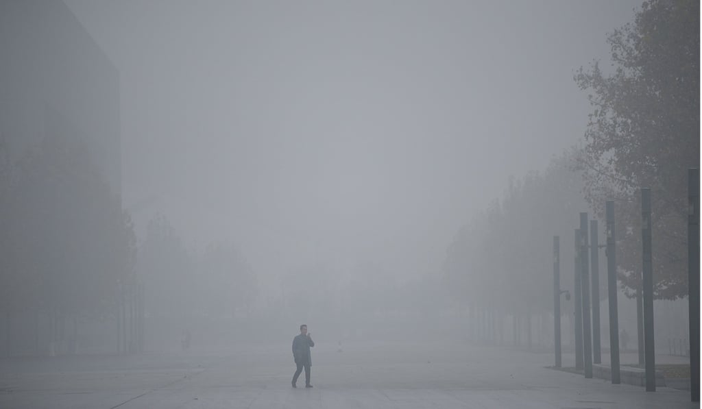A man uses his mobile phone as he walks amid smog in Tianjin. Air pollution is particularly severe during winter in China. Photo: Reuters