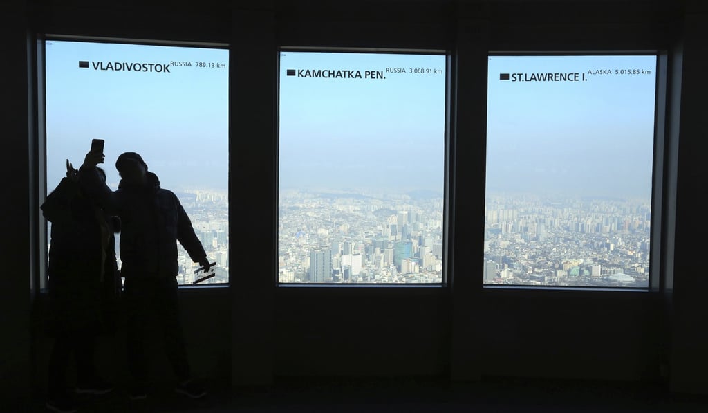 A couple takes pictures of the city skyline at Seoul observation deck. Photo: AP A couple takes pictures of the city skyline at Seoul observation deck. Photo: AP