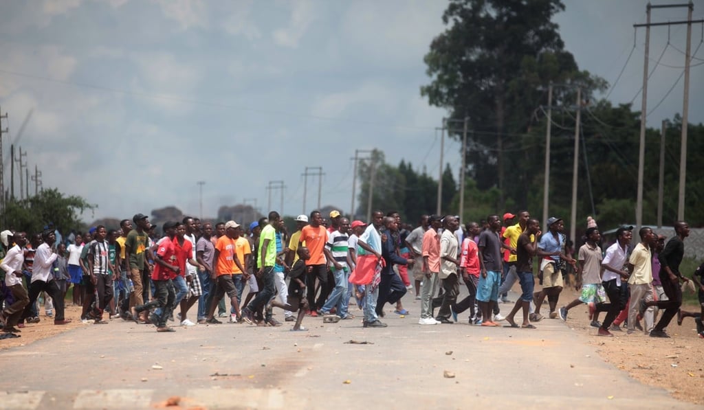 Protestors crossing a road in Epworth, Harare, Zimbabwe on January 14, 2019. Photo: EPA