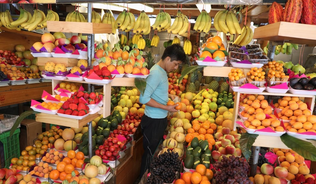 A vendor selects fruit for sale at a market in Lima, Peru November 2, 2018. Photo: Reuters