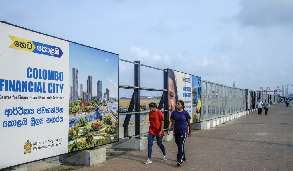 Pedestrians walk past hoardings advertising the Colombo International Financial City project. Photo: Bloomberg