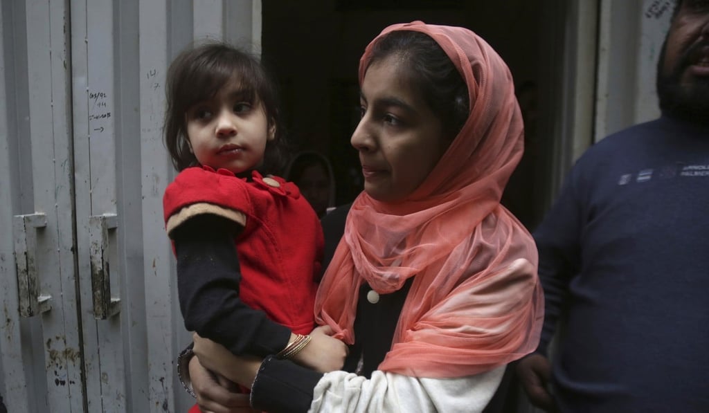 Hadiya Khalil (left), who survived the shoot-out, carried by an unidentified relative at her home in Lahore on January 20, 2019. Photo: AP
