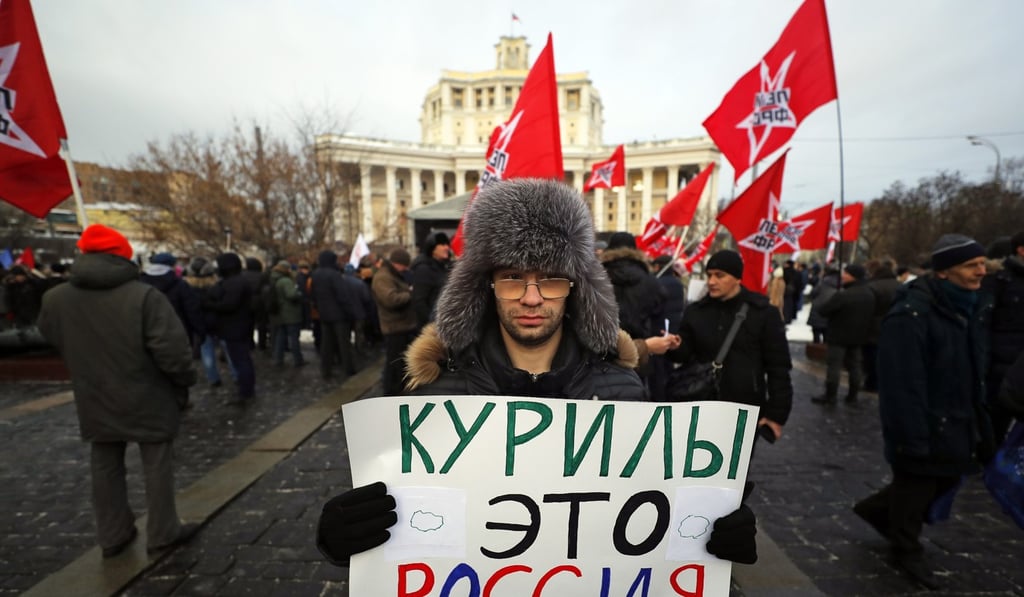 A Russian activist holds a banner that says “The Kuril islands are Russia” during a rally protesting their mooted handover to Japan. Photo: EPA