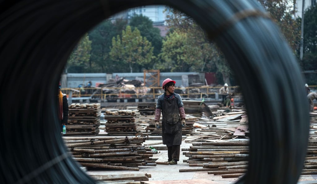 A woman works at a construction site for a residential skyscraper in Shanghai. Residential properties under construction in China add up to close to six billion square metres. Photo: AFP
