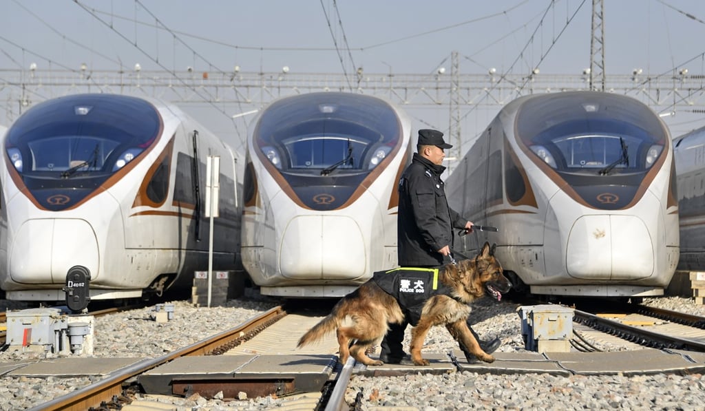 A railway policeman patrols with a police dog at a maintenance station in Beijing on Saturday ahead of the travel rush. Photo: Xinhua