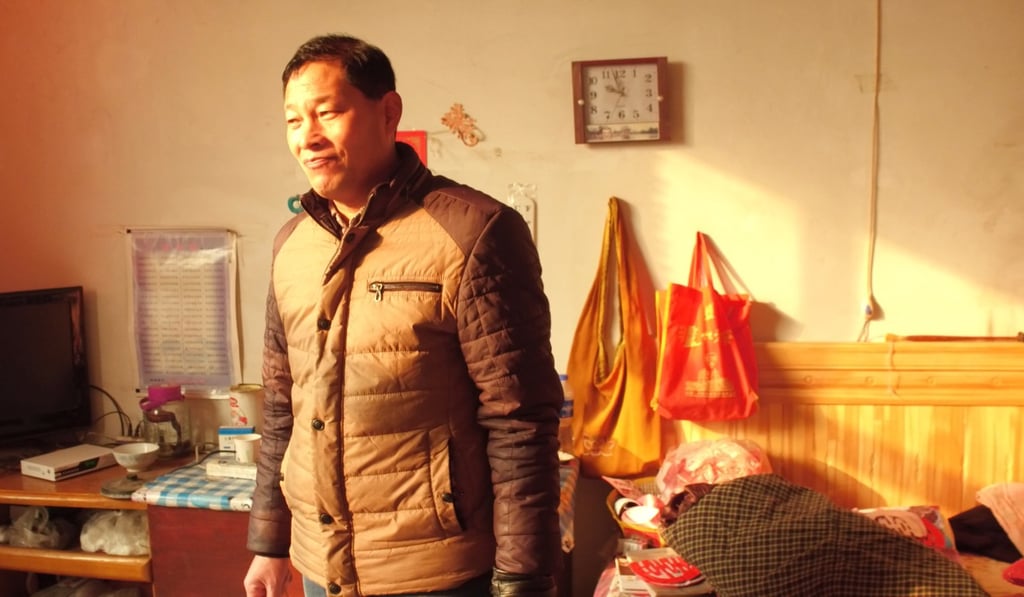 Nie’s home is so cold he keeps his coat on indoors. Photo: Thomas Yau