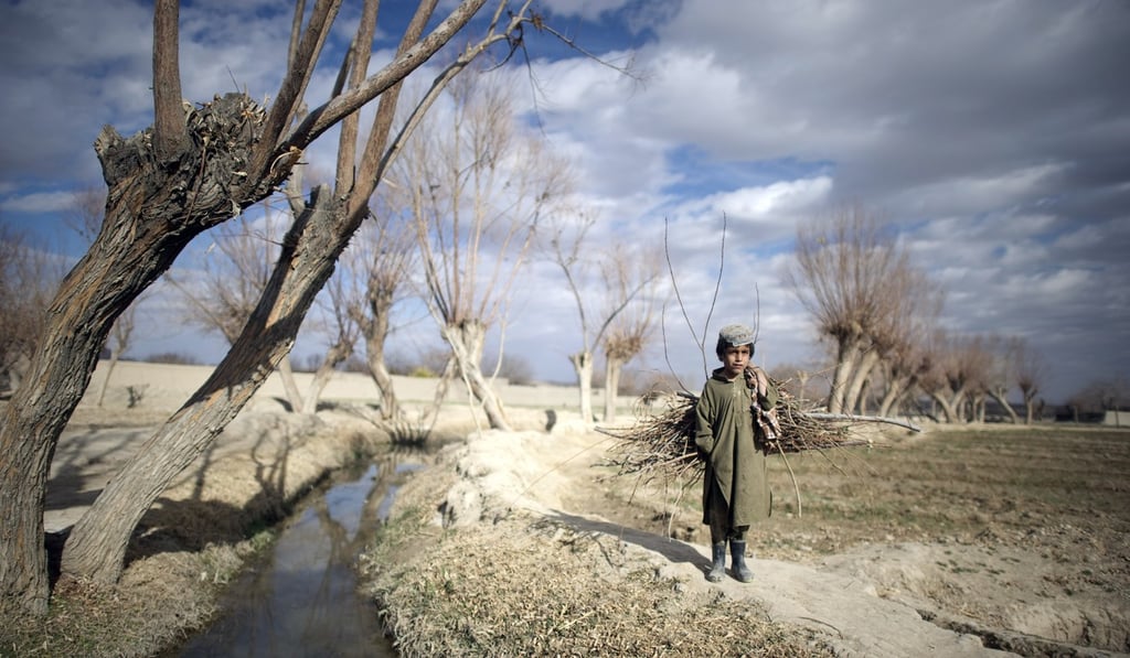 An Afghan boy watches US Marines on a foot patrol. Photo: AFP