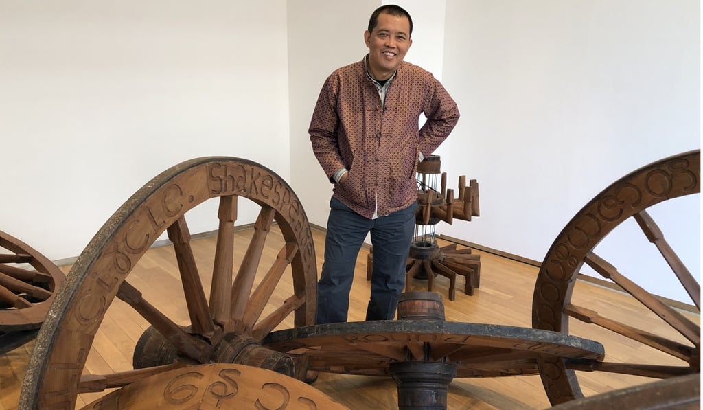 Artist Htein Lin posing with his sculpture “Immobilised” (2018).