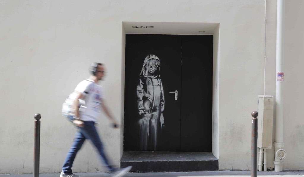 In this file photo taken on June 25, 2018 A man walks past an artwork by street artist Banksy in Paris on a side street to the Bataclan concert hall where a terrorist attack killed 90 people on November 13, 2015. Photo: AFP In this file photo taken on June 25, 2018 A man walks past an artwork by street artist Banksy in Paris on a side street to the Bataclan concert hall where a terrorist attack killed 90 people on November 13, 2015. Photo: AFP