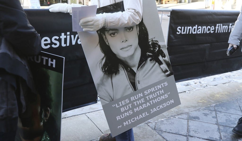 A woman holds up a poster outside the Egyptian Theatre on Friday when it held the premiere of HBO’s Leaving Neverland Michael Jackson documentary film during the 2019 Sundance Film Festival in Park City, Utah. Photo: AP