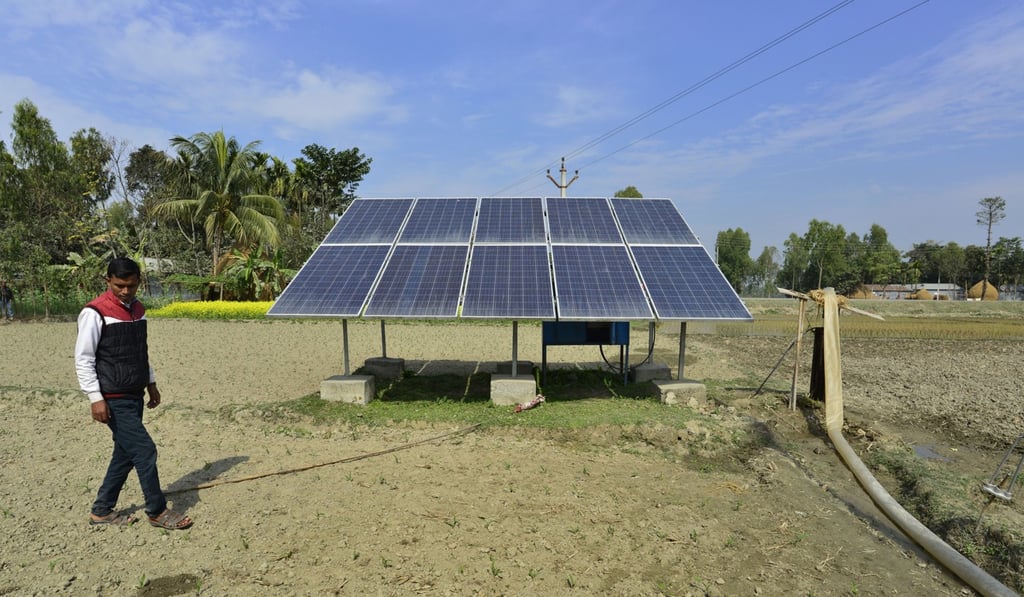 Indian farmers work near a newly installed water pump that relies on solar power. Photo: EPA