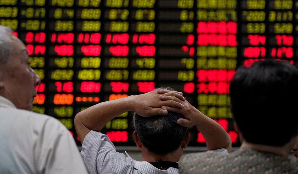 Investors look at an electronic board showing stock information at a brokerage house in Shanghai. Photo: Reuters