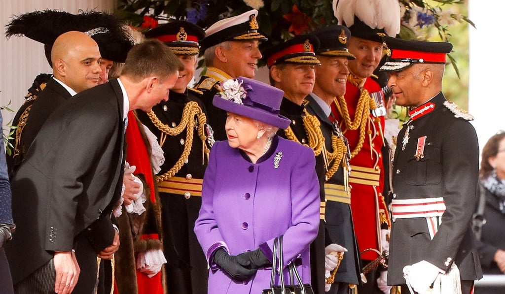 Britain's Queen Elizabeth, centre, speaks with Jeremy Hunt. Photo: Bloomberg photo by Luke MacGregor