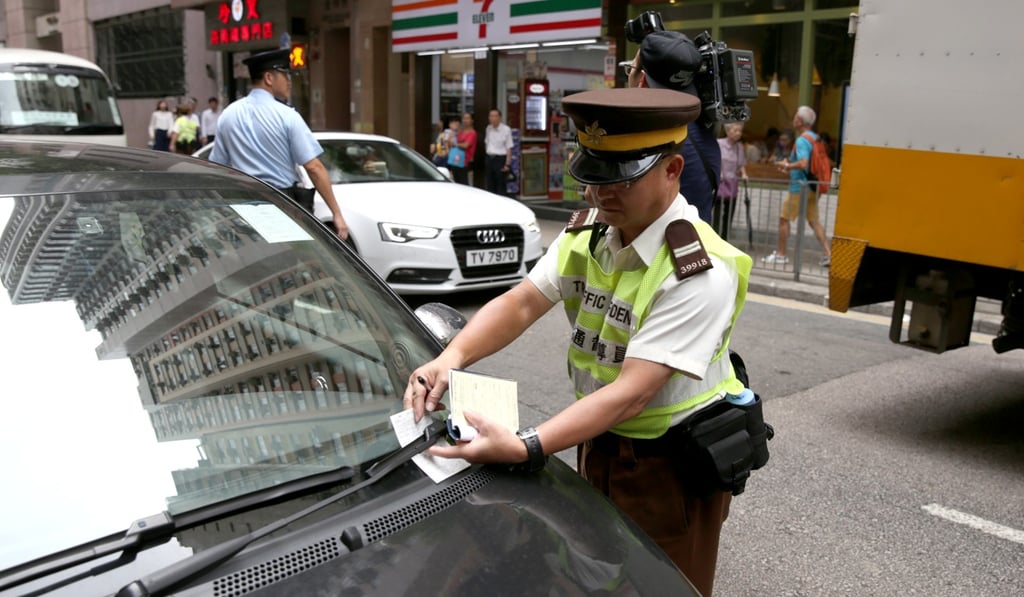 A traffic warden issues a ticket for illegal parking in Tsat Tsz Mui Road in North Point. Photo: Sam Tsang